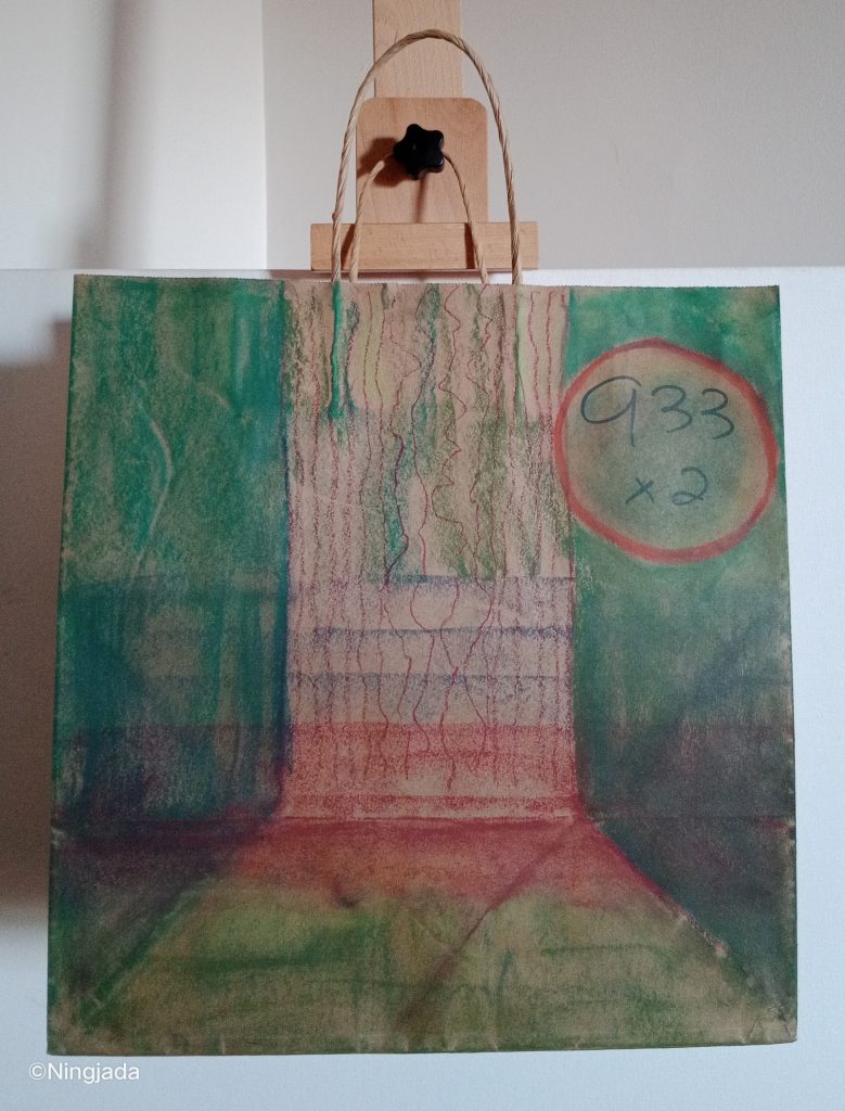 A brown paper bag has an image drawn on it with shades of dark green, teel, red, purple and olive green. The left and right side of the bag is coloured in a deep teel and dark green shades, with the shades getting mixed with the colour red lower on the bag creating a deep purple shade. The middle of the bag is a trunk, with thin red squiggly lines drawn vertically down to create texture of a tree. The base of the tree widens out in a pyramid shape, and is coloured with a grassy green shade. The top right of the bag has “933x2” written on it, and is circled in red. The bag is hanging on a wooden easel in front of a white wall.