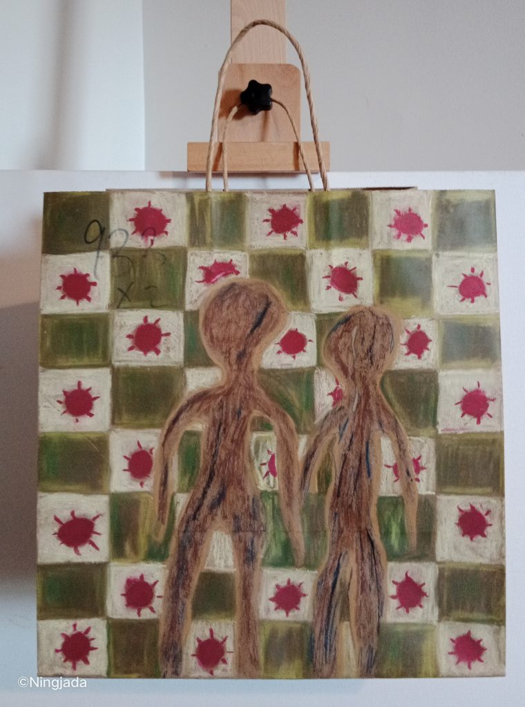 A brown paper bag has two brown silhouetted figures. The figures are standing next to each other with the arms touching each other. The figures are shaded in with a mixture of light brown, dark brown and black. The background is patterned with checkered squares. One square is dark mustard green, and the other is a red circle with eight short lines poking out of the circle evenly distributed around it, and a white background behind it. The number “933 x2” is faintly written in black pen in the top left of the bag under the layered drawing. The bag is hanging on a wooden easel, in front of a white wall.